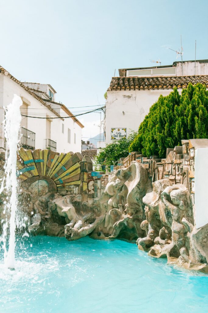 Ceramic sculpture and fountain on Calle del Mar in Estepona old town, framed by whitewashed houses with terracotta roof tiles