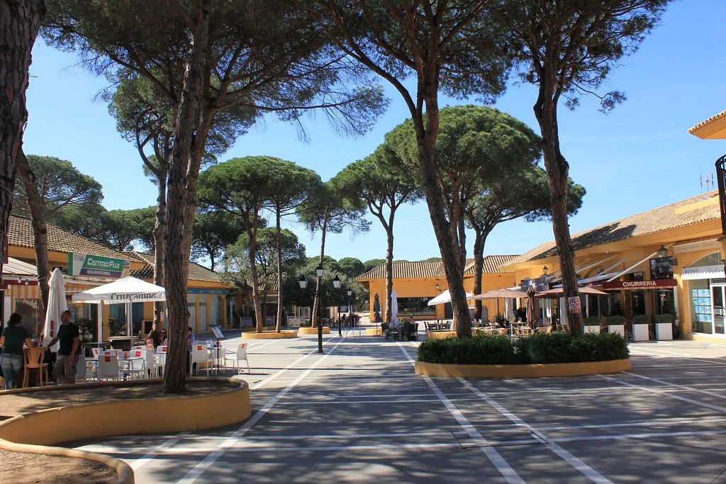 Restaurant terraces under the pines at Elviria's commercial square, Marbella
